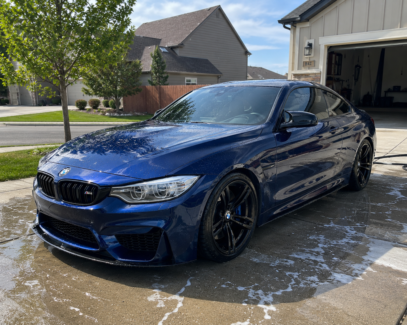 Freshly detailed blue BMW M4 with deep gloss paint shine in a Mississauga driveway